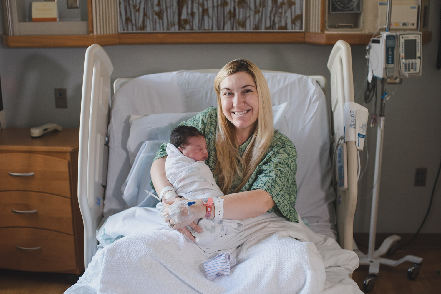 New mother with newborn son in hospital bed.